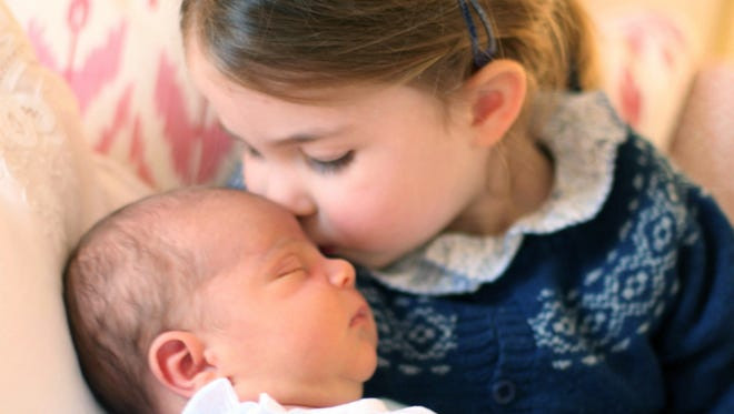 Tiểu Công chúa Charlotte hôn lên trán em trai, tiểu Hoàng tử Louis, tại Cung điện Kensington ngày 27/4/2018. Ảnh: EPA.