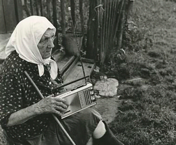 Người phụ nữ lớn tuổi ngồi trước nhà. Bức ảnh chụp năm 1981.