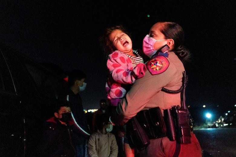 Một bé gái di cư khóc khi được nhân viên tuần tra Mỹ bế tại Roma hôm 5/4. 