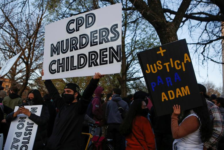 Người biểu tình mang theo những tấm biển phản đối hành vi của cảnh sát, đồng thời đòi công lý cho Adam. Ảnh: Reuters.