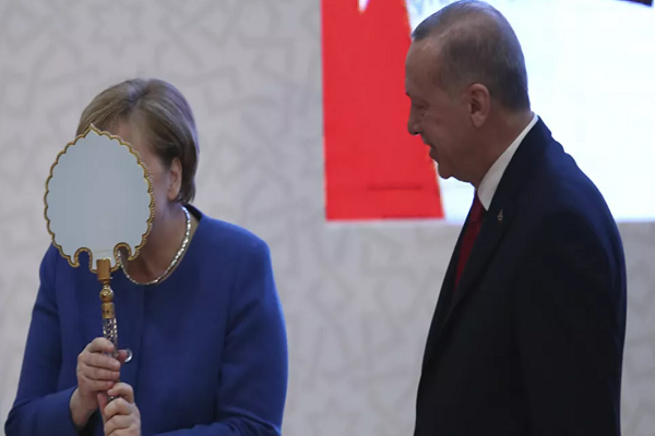 Thủ tướng Đức Angela Merkel (trái) có hành động hài hước khi nhận được chiếc gương mà Tổng thống Thổ Nhĩ Kỳ Recep Tayyip Erdogan (phải) tặng bà trong lễ khai trương cơ sở mới của trường Đại học Thổ Nhĩ Kỳ - Đức ở thành phố Istanbul, Thổ Nhĩ Kỳ, ngày 24/1/2020. Ảnh: Sputnik.