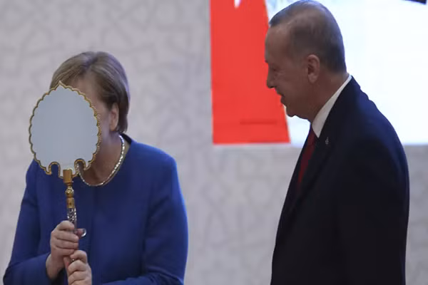 Thủ tướng Đức Angela Merkel (trái) có hành động hài hước khi nhận được chiếc gương mà Tổng thống Thổ Nhĩ Kỳ Recep Tayyip Erdogan (phải) tặng bà trong lễ khai trương cơ sở mới của trường Đại học Thổ Nhĩ Kỳ - Đức ở thành phố Istanbul, Thổ Nhĩ Kỳ, ngày 24/1/2020. Ảnh: Sputnik.
