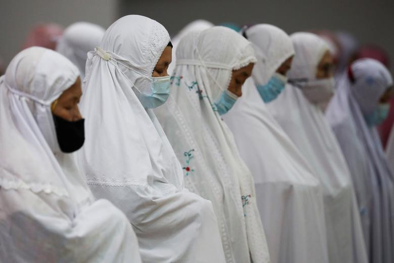 Những người phụ nữ đeo khẩu trang phòng dịch COVID-19 khi cầu nguyện tại Kuala Lumpur, Malaysia, ngày 13/4/2021.