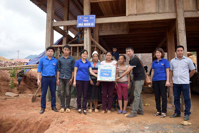 Bà Nguyễn Minh Tâm (thứ 3 từ trái sang) cùng đại diện Báo Thanh Niên tặng nhà cho gia đình anh Bùi Văn Hòa và chị Quách Thị Xiên (H.Đà Bắc, Hòa Bình). ẢNH: GIA HÂN