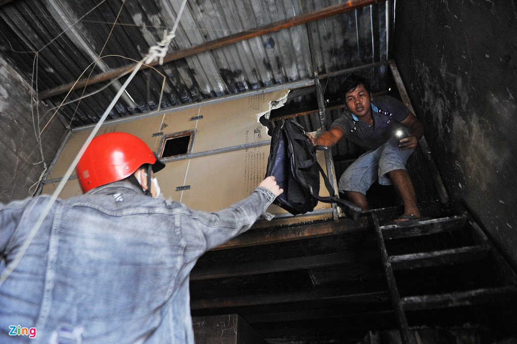 Anh Tường, bạn của Mỹ, đến phụ giúp thu dọn đồ đạc sau đám cháy. Căn gác lửng ám khói đen nghịt, chỉ còn lại vài túi xách bị cháy xém.