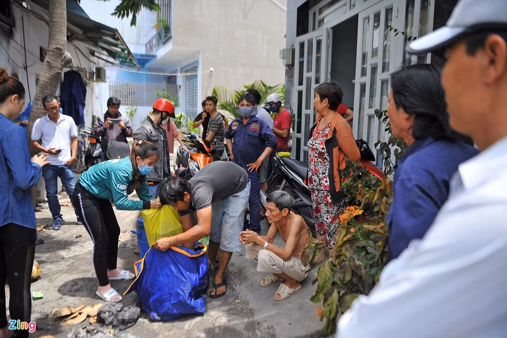 Nhiều người dân ở khu xóm trọ đến phụ giúp dọn dẹp sau vụ cháy.