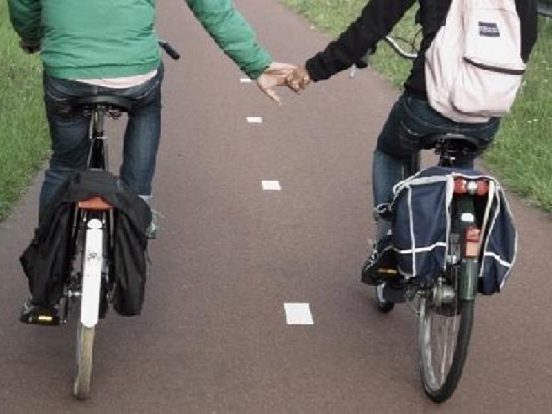 Hình ảnh cả hai nắm tay khi cùng đi xe đạp.
