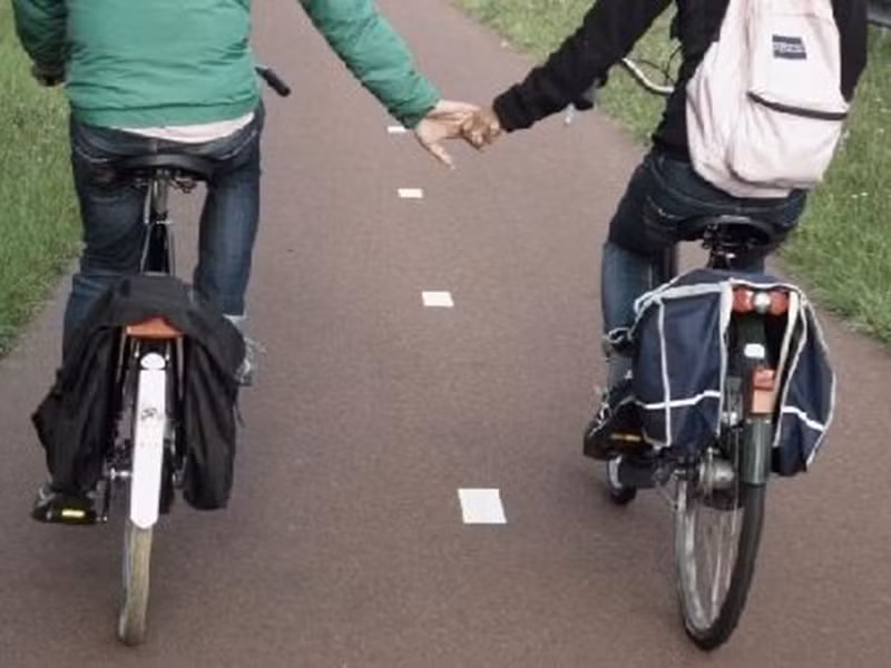 Hình ảnh cả hai nắm tay khi cùng đi xe đạp.