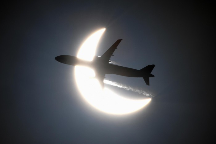 Chiếc máy bay như một mũi tên, xuyên qua Nhật thực. Một phần máy bay tạo thành bóng đen che lấp mặt trời.