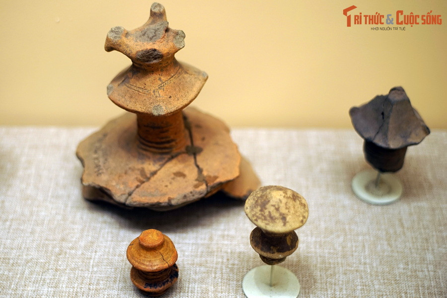 Mô hình tháp bốn mái trên đỉnh có gắn tượng hình chim, các trụ gốm hình con tiện, chân đế choãi trang trí văn khắc vạch, tượng hình chim… cũng phát lộ với số lượng lớn, cho thấy đây là biểu tượng có ý nghĩa quan trọng đối với dân cư Giồng Cá Vồ. Ảnh: Núm trang trí hình tháp trên nắp đồ đựng Giồng Cá Vồ.