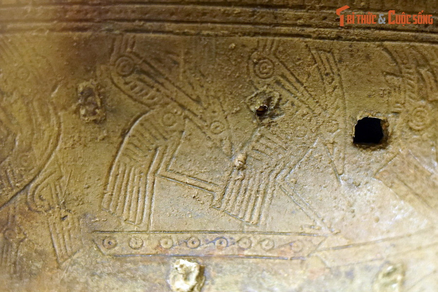 Hình cặp chim có mào, mỏ dài, chân cao, đuôi dài, con nọ đứng trên lưng con kia như đang đạp mái, trên phần tang trống của trống đồng Hoàng Hạ.