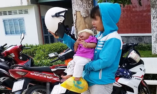 Thiếu nữ vẫn còn khóc khi ôm con rời tòa. Ảnh: Việt Tường.