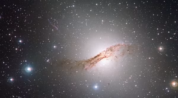 Xung quanh thiên hà Centaurus A dày đặc bụi dưới dạng những vệt đen, đĩa thiên hà bị cong vênh rõ ràng.
