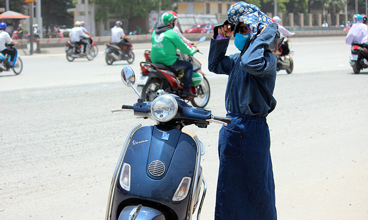 Nắng nóng gay gắt khiến nhiều người dân Hà Nội điều khiển xe máy đi ngoài đường phải "ngụy trang" như...ninja.