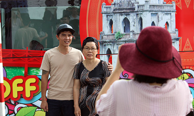 Nhiều người dân Thủ đô tranh thủ chụp hình với xe buýt trước khi lên xe du lịch vòng quanh Hà Nội.