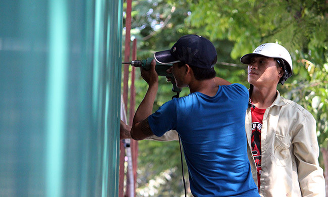 Các công nhân vẫn đang khẩn trương quây tôn ở các đoạn đường tại khu đất để tiến hành việc cưỡng chế, phá dỡ.