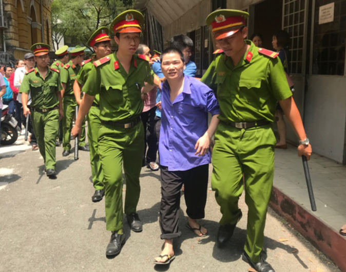 Cảnh sát dẫn giải bị cáo Nhàn sau phiên xét xử. Ảnh NĐT.