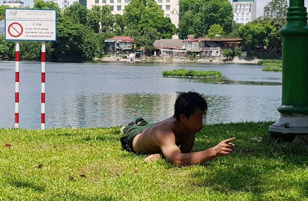Nam thanh niên nằm lăn lóc, gặm cỏ ở hồ Thiền Quang.