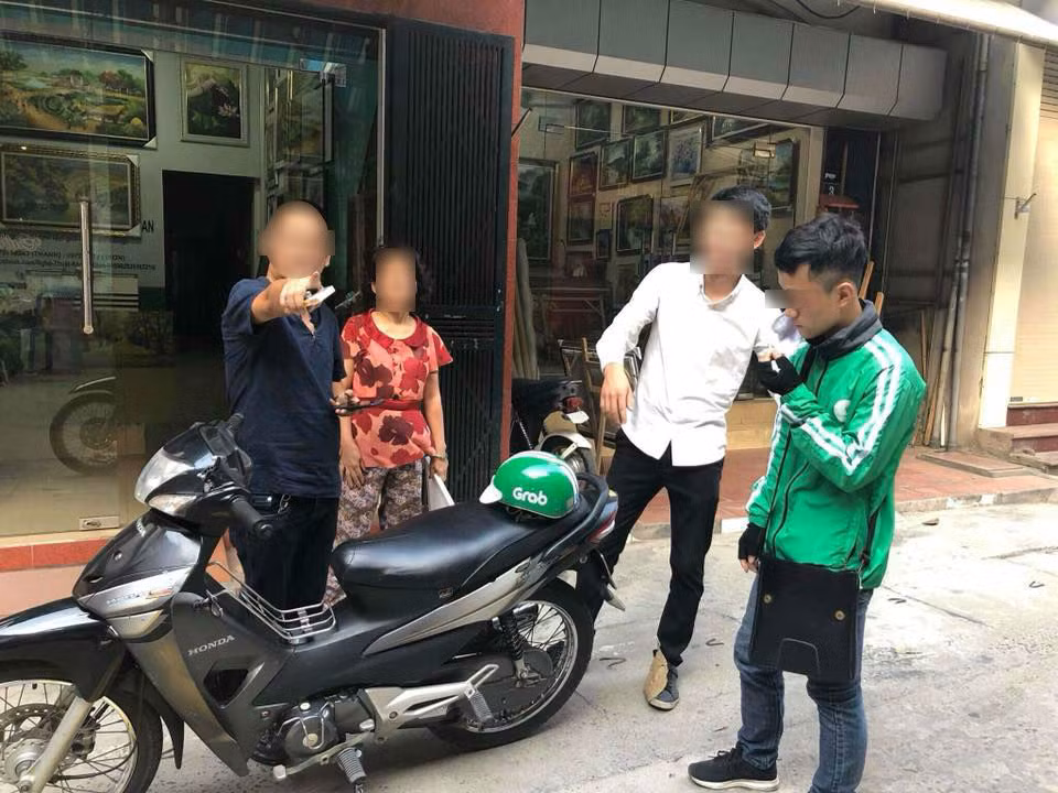 Người đàn ông (mặc áo đen) vô cớ hành hung tài xế Grab Bike và lớn tiếng chửi bới, chỉ tay hăm dọa vị khách của tài xế này. Ảnh: Joog Nguyen.