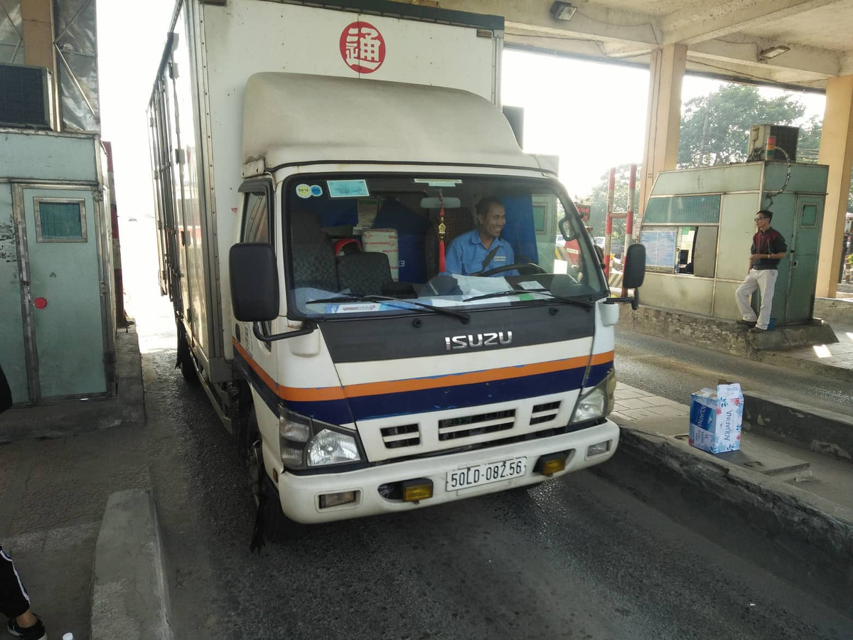 Tài xế lái xe cười tươi khi đi qua trạm.