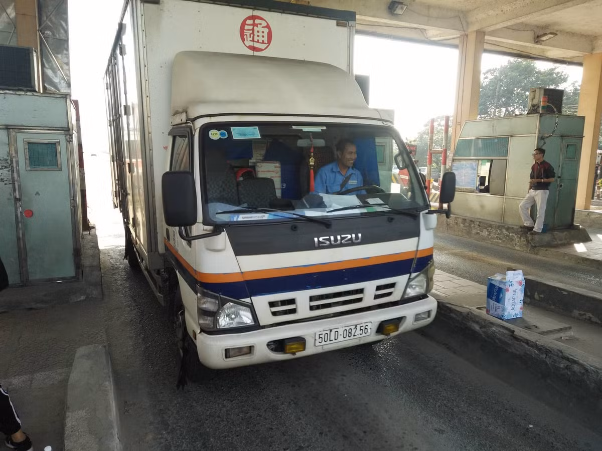 Tài xế lái xe cười tươi khi đi qua trạm.