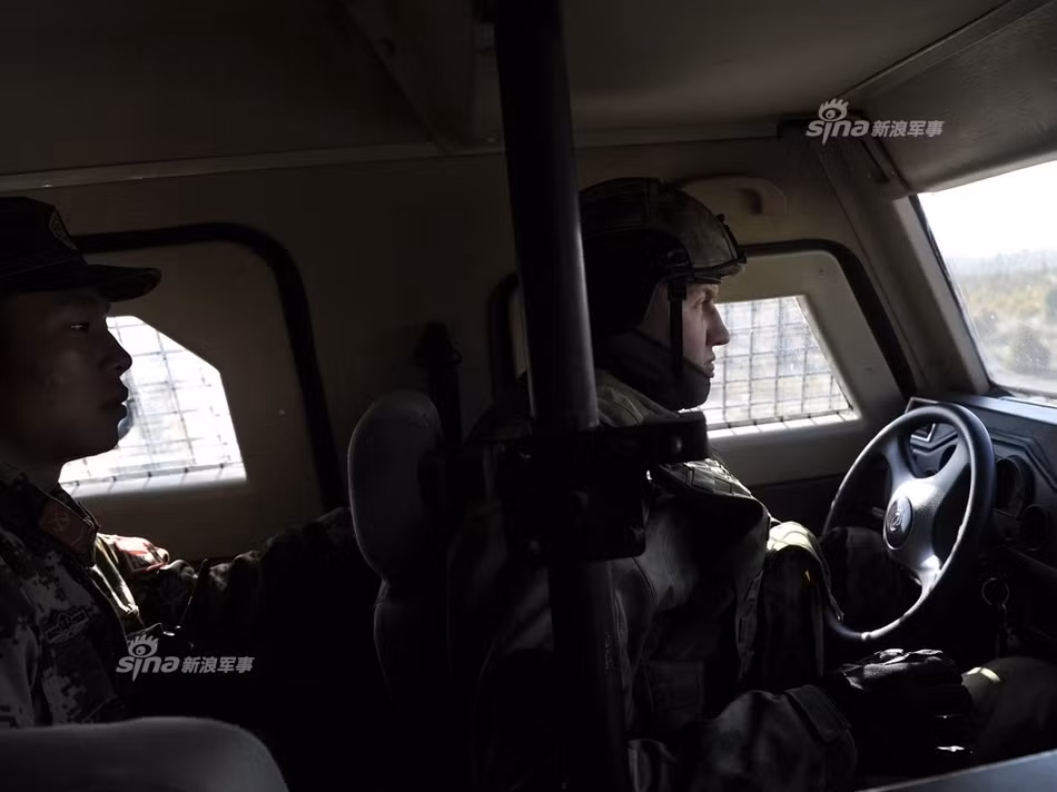 Binh lính Nga lái xe chở theo một binh lính Trung Quốc trong cuộc tập trận chung chống khủng bố của hai bên. Nguồn ảnh: Sina.