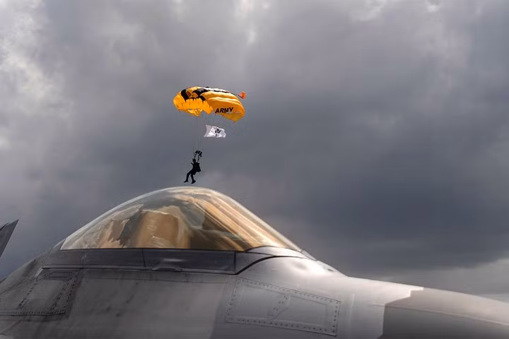 Binh sĩ Mỹ nhảy dù gần một chiếc tiêm kích F-22 Raptor.