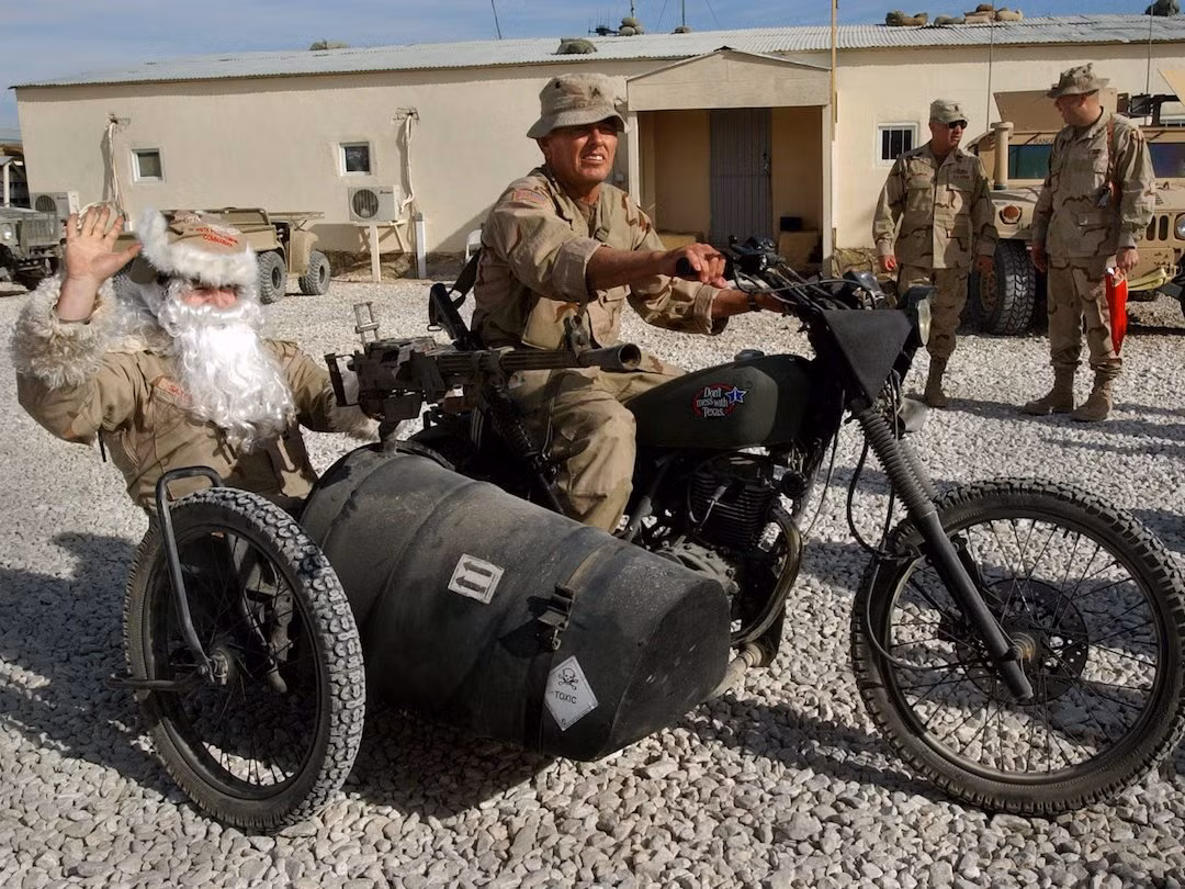 Ông già Noel trong một căn cứ quân sự của Mỹ ngồi xe gắn máy với súng máy để phía trước. Nguồn ảnh: BI.