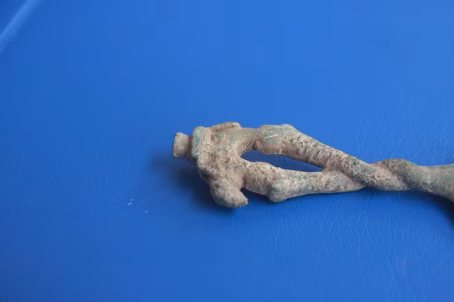 Chuôi dao có hình hai con rắn thân tròn xoắn lấy nhau, một con có mào và một con không có mào. Hai con rắn đang há miệng đỡ lấy cặp chân sau và cặp chân trước của một con voi.