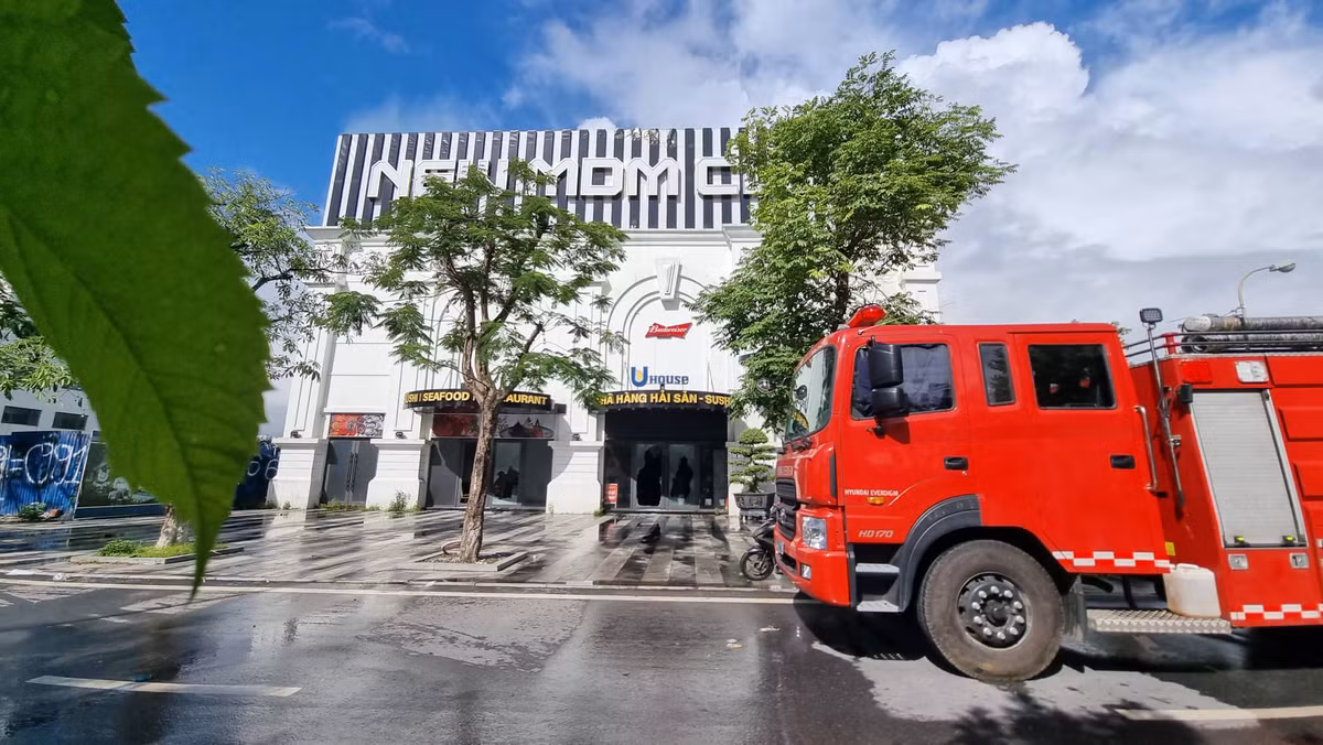 Do tòa nhà màu trắng nên phía sau những mảng khói đen vẫn còn bám dầy đặc ở các góc tường. 2 chiếc xe cứu hỏa cùng một số cán bộ chiến sĩ vẫn có mặt ở đám cháy. 