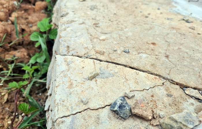 Cận cảnh lớp bê tông phủ bề mặt đường đã bị hư hỏng, rạn nứt.