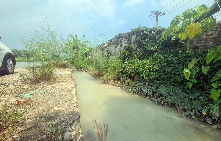 Mương nước phía trước cửa trạm trộn bê tông Thiên Tân đã bị ô nhiễm nghiêm trọng. Bằng mắt thường cũng dễ dàng nhìn thấy, từng mảng váng bê tông kết tủa thành màu trắng xóa chạy dài trên mặt nước.