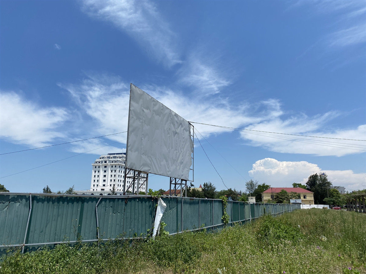 Những dòng áp phích quảng cáo bên ngoài dự án đã rách tả tơi theo thời gian, các dòng chữ trên 2 cổng chính vào dự án không còn nguyên vẹn. (Ảnh: Tài nguyên và Môi trường).