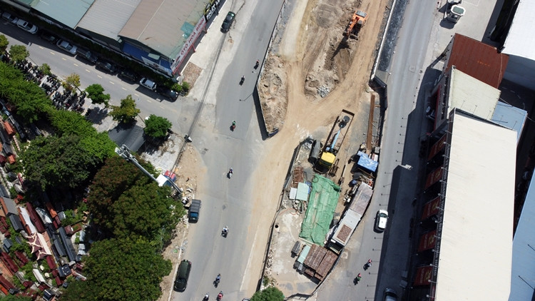 Máy móc đang thi công các hạng mục đường dẫn xuống hầm chui ở trục Lê Văn Lương.