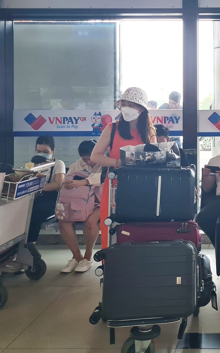 Một nữ khách hàng đang chờ đợi làm thủ tục lên máy bay.