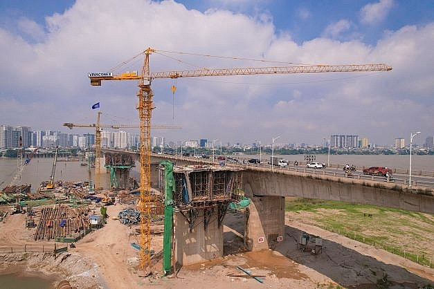 Để đẩy nhanh tiến độ, liên danh nhà thầu đang huy động 500 công nhân làm việc 3 ca, 10 sà lan 1.000 tấn vận chuyển vật liệu trên sông, 3 trạm trộn bê tông cùng nhiều máy móc, thiết bị khác trên bờ để đồng bộ thi công trụ cầu. (Ảnh: Báo Xây dựng).