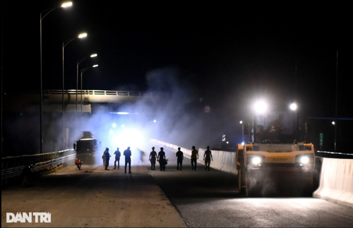 Hàng trăm công nhân chia làm nhiều ca gấp rút thi công các hạng mục như thảm nhựa, sơn vạch kẻ đường, lắp đặt hệ thống biển báo... để kịp tiến độ bàn giao. (Ảnh: Dân Trí).