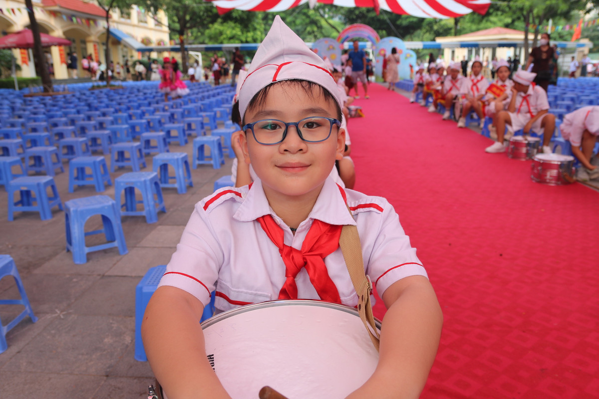 Một học sinh cũng đến trường sớm, em nằm trong đội trống mừng khai giảng.