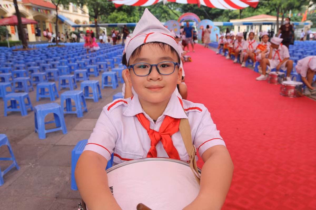 Một học sinh cũng đến trường sớm, em nằm trong đội trống mừng khai giảng.