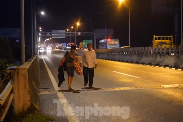 Nhiều người trên xe khách và các phương tiện gặp nạn phải đi bộ đến trạm thu phí Long Phước nghỉ ngơi trong lúc lực lượng chức năng xử lý hiện trường. (Ảnh: Tiền Phong)