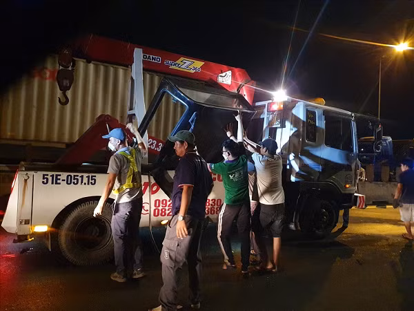 Lực lượng chức năng cứu hộ vận chuyển, kéo xe gặp nạn khỏi hiện trường. (Ảnh: Lao động)