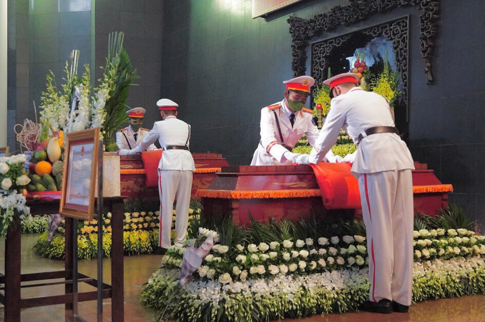 Nghi thức phủ cờ lên áo quan các liệt sĩ được đội danh dự tiến hành trang nghiêm.