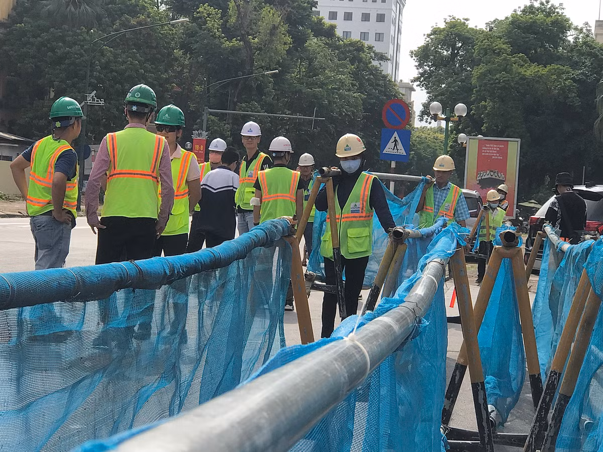 9h sáng, Thanh tra giao thông và công nhân bắt đầu dựng rào chắn phân luồng.