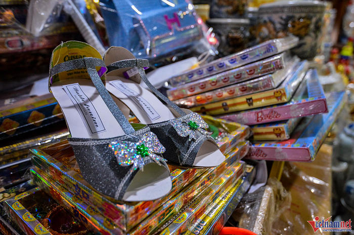 Một đôi giày cao gót giấy được làm tỉ mỉ như thật. Đây là loại đồ dùng cho người cõi âm có mẫu mã mới, đính nhiều "kim tuyến". Nhằm thu hút người tiêu dùng, một số chủ cửa hàng lựa chọn từng sản phẩm riêng lẻ rồi ghép thành bộ để dễ bán.