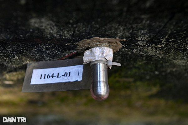 Bà Quỳ chỉ cho phóng viên điểm đóng cọc đo độ lún, tỏ ra chán nản vì biết đến bao giờ người dân mới thôi phải "kêu cứu". (Ảnh: Dân trí)