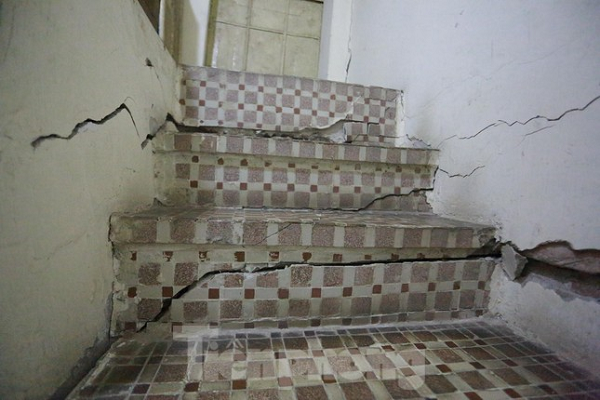 Khi bước lên những bậc cầu thang nhà ông Đa sẽ cảm nhận được hiện tượng nghiêng, cộng với các vết nứt to tiềm ẩn nguy cơ đổ sập bất kỳ lúc nào. Dẫu lo lắng nhưng hàng ngày, ông già 81 tuổi vẫn phải di chuyển qua những bậc thang nứt toác, lên tầng 2 để phơi đồ, cho mèo ăn. (Ảnh: Tiền Phong)