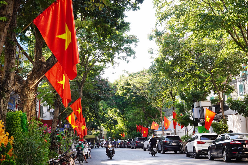 Sắc vàng nắng thu Hà Nội hòa với sắc đỏ của cờ, phướn làm những con phố Thủ đô thêm rực rỡ.