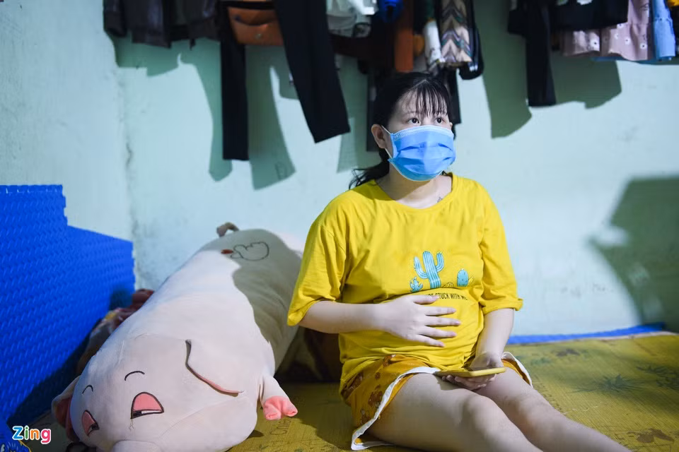 Ngồi một mình trong căn phòng trọ chừng 15 m2, chị Vi Thị Huyền xoa chiếc bụng bầu đã 7 tháng, mắt rơm rớm vì nhớ chồng. Công ty chồng chị có F0, vì vậy anh được xác định là F1 và đã đi cách ly hơn chục ngày nay. Ngày nào bố mẹ ở Nghệ An cũng điện lên hỏi thăm, dặn dò chị không được nghĩ ngợi nhiều. Còn mỗi khi chồng gọi điện, chị lại nhung nhớ: “Em nhớ anh lắm, anh giữ gìn sức khỏe, sớm về với mẹ con em”.