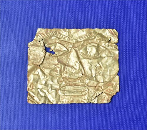 Mặt nạ vàng Giồng Lớn 3 có hình chữ nhật. Phần mặt trước in nổi khuôn mặt người với đôi mắt mở to, đôi lông mày rậm giao nhau, mũi to, môi dày. 4 góc và gần phía dưới môi được đục lỗ để xỏ dây. Đây là một chiếc mặt nạ thuộc dạng full-face, tức là thể hiện toàn bộ đặc điểm của khuôn mặt.