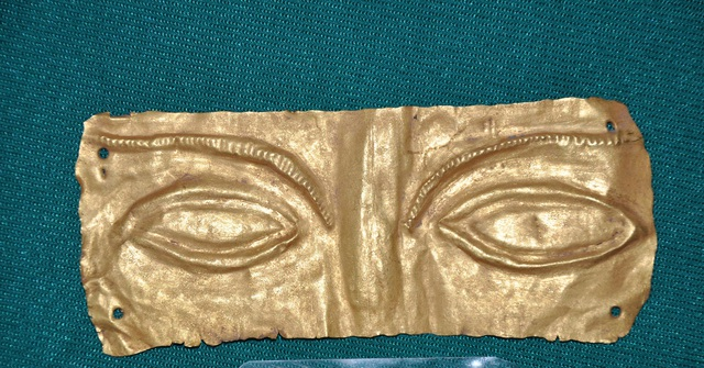 Về hình dáng, mặt nạ vàng Giồng Lớn 1 hình chữ nhật, phần mặt trước in nổi hình đôi mắt mở to và một phần sống mũi. Phía trên mắt là đôi lông mày dài, thanh tú với phần đầu thấp ngang mí mắt, thân cong dần lên trên và đuôi mày cao vút. Đây là chiếc mặt nạ dạng eye-cover, nghĩa là chỉ thể hiện nửa mặt phía trên, chủ yếu là đôi mắt.